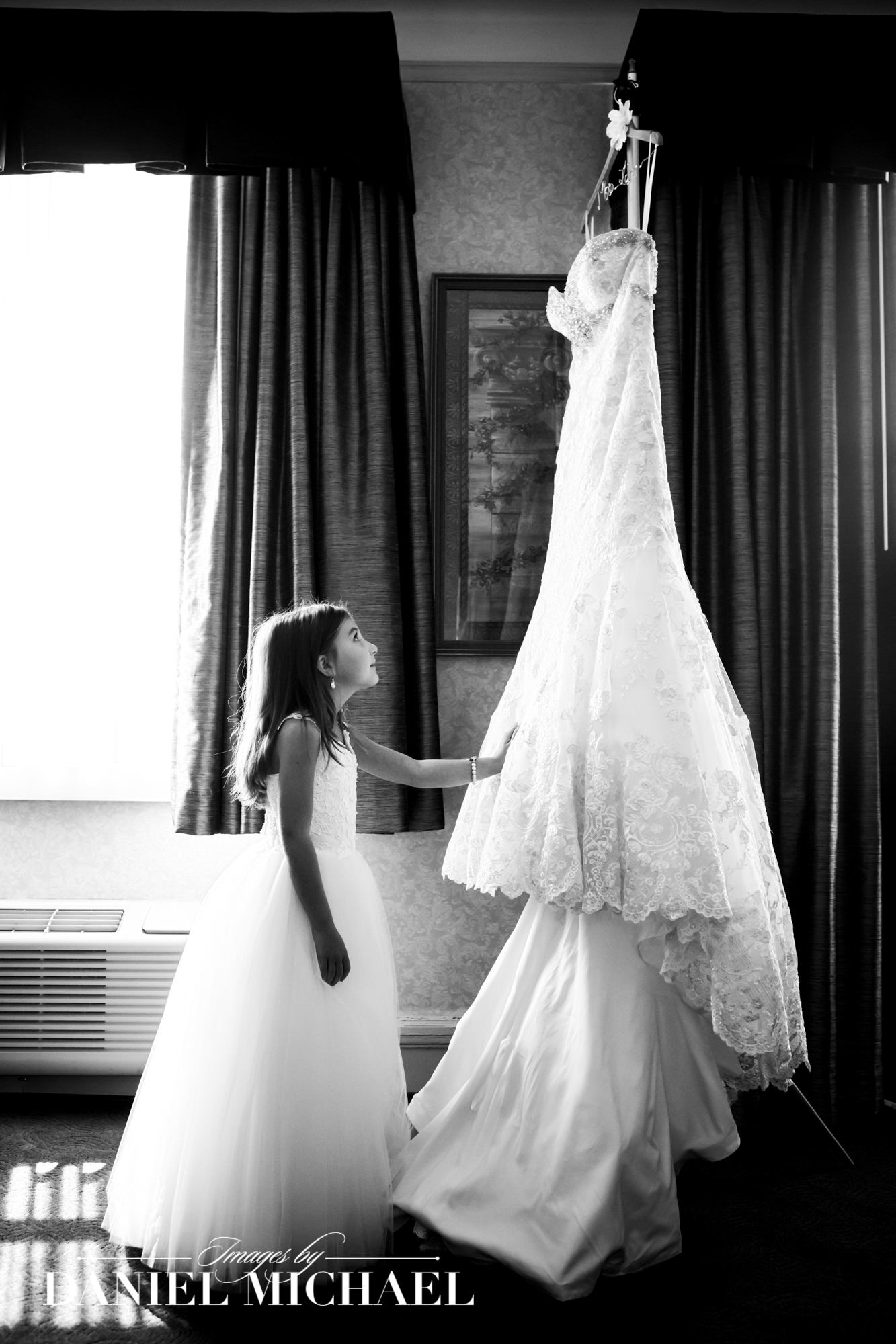 Natural Wedding Photography of Flower Girl admiring Bride's Dress